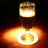 Glass med mørkt øl og masse skum